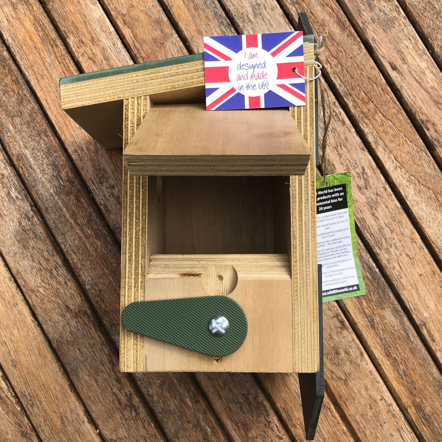 Wooden birdhouse with a British flag tag showing side opening for cleaning